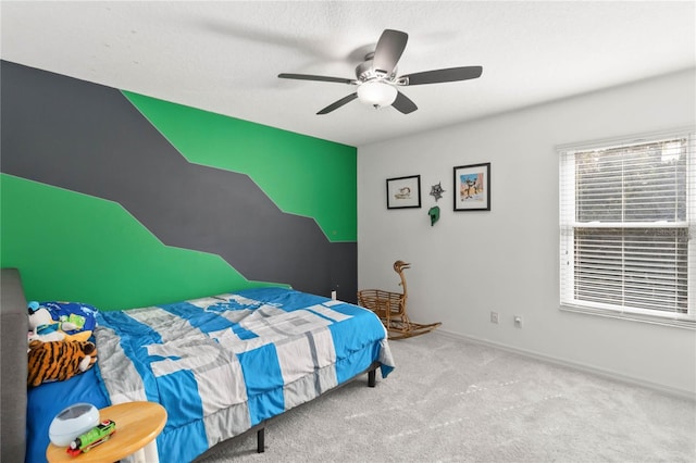 bedroom featuring light colored carpet, a textured ceiling, and ceiling fan