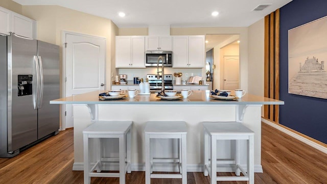 kitchen with stainless steel appliances, a kitchen island, and a breakfast bar area