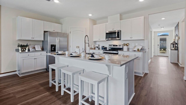 kitchen featuring white cabinetry, appliances with stainless steel finishes, and a center island with sink