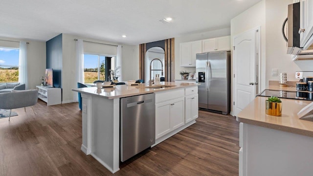 kitchen with sink, white cabinetry, stainless steel appliances, dark hardwood / wood-style floors, and an island with sink