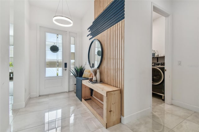 entrance foyer with light tile patterned floors and washer / dryer