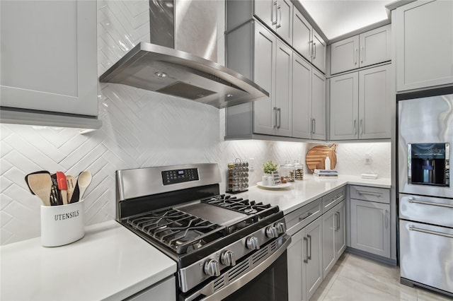 kitchen with stainless steel appliances, extractor fan, tasteful backsplash, and gray cabinetry