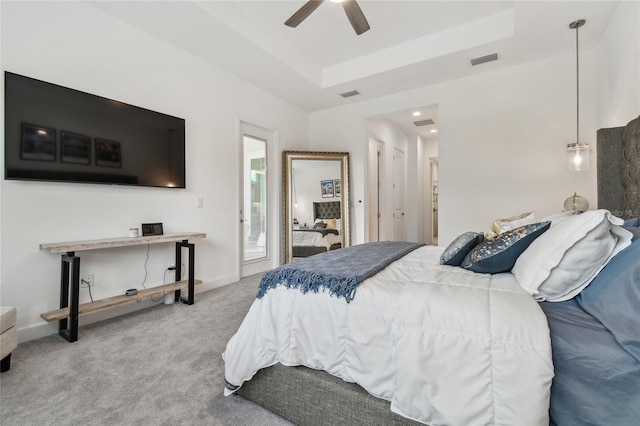 bedroom featuring a raised ceiling, carpet floors, and ceiling fan