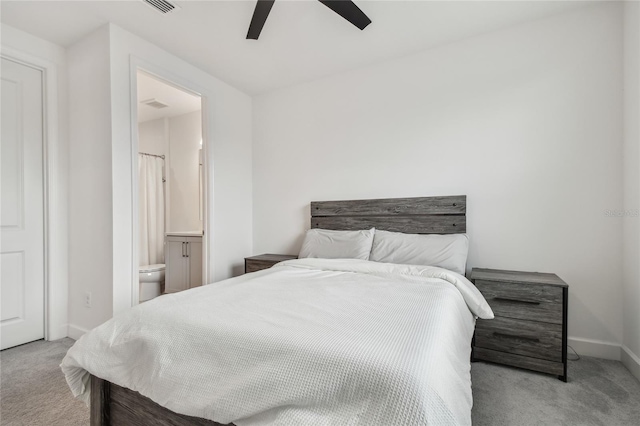 carpeted bedroom with ensuite bath and ceiling fan