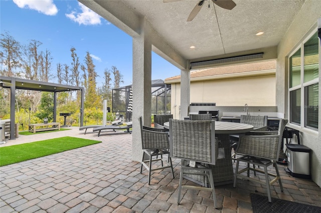 view of patio / terrace with ceiling fan and glass enclosure