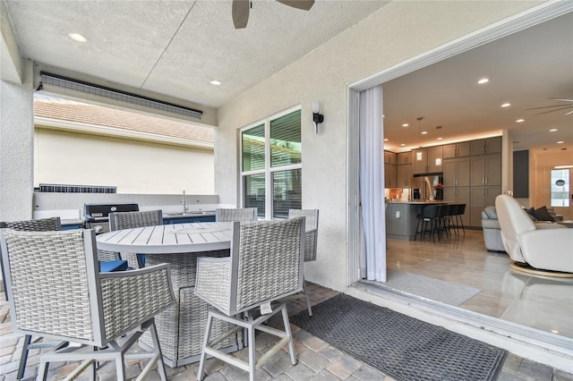 view of patio with ceiling fan and an outdoor bar