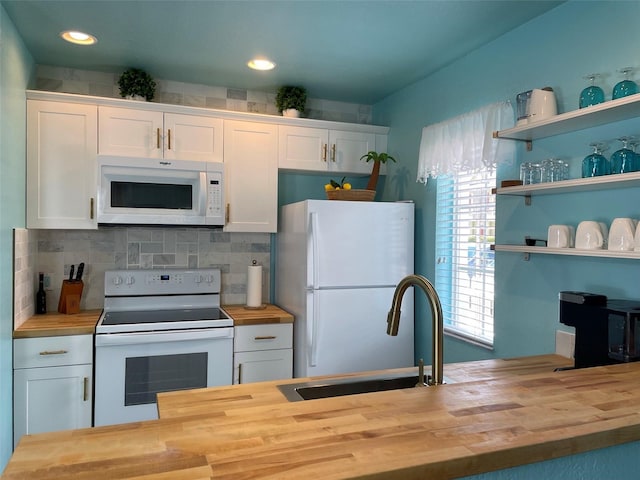 kitchen with wood counters, a healthy amount of sunlight, white appliances, and white cabinets