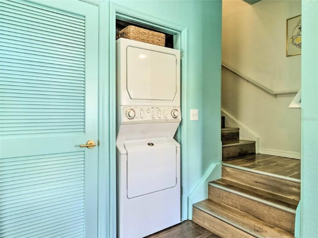 washroom featuring stacked washer and clothes dryer and dark hardwood / wood-style flooring