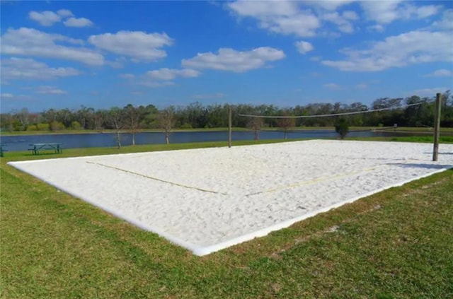 view of home's community featuring a water view, a lawn, and volleyball court