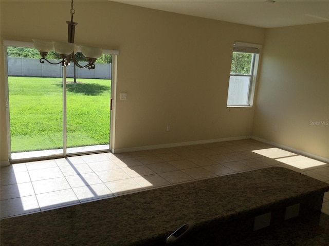 spare room featuring an inviting chandelier and light tile patterned floors