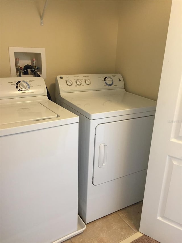 laundry area featuring washer and dryer and light tile patterned flooring