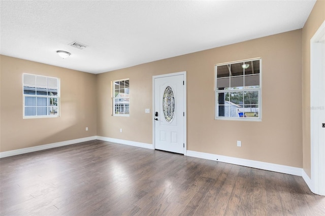 entrance foyer with dark wood-type flooring and a textured ceiling