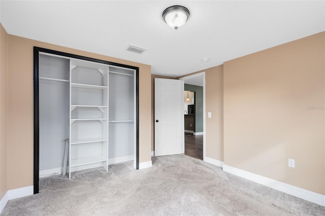 unfurnished bedroom featuring light colored carpet and a closet