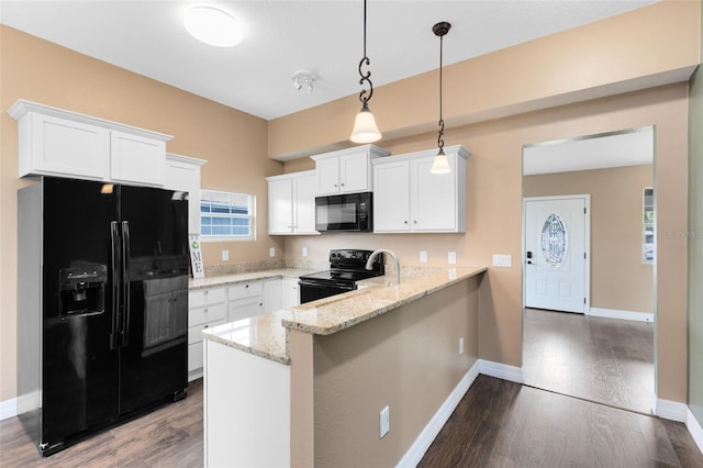 kitchen with decorative light fixtures, kitchen peninsula, white cabinets, and black appliances