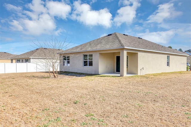 rear view of property featuring a patio and a lawn