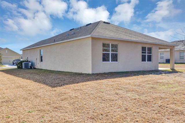 view of property exterior with a yard and central air condition unit