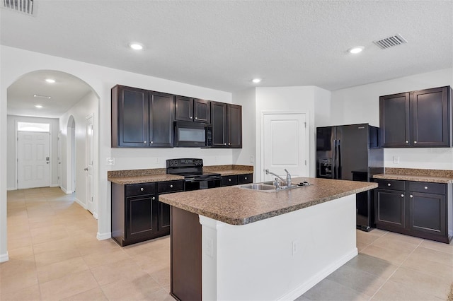 kitchen featuring a kitchen island with sink, sink, black appliances, and dark brown cabinetry