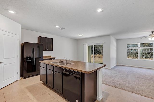 kitchen featuring sink, a kitchen island with sink, light colored carpet, dark brown cabinetry, and black appliances