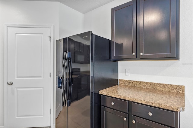 kitchen with black fridge with ice dispenser, dark brown cabinets, and tile patterned floors