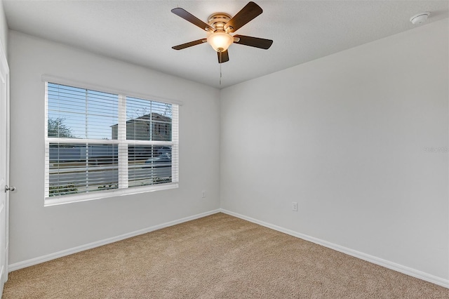 empty room featuring a textured ceiling, carpet floors, and ceiling fan