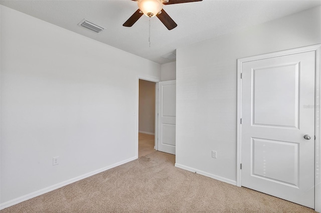 unfurnished bedroom featuring light colored carpet and ceiling fan