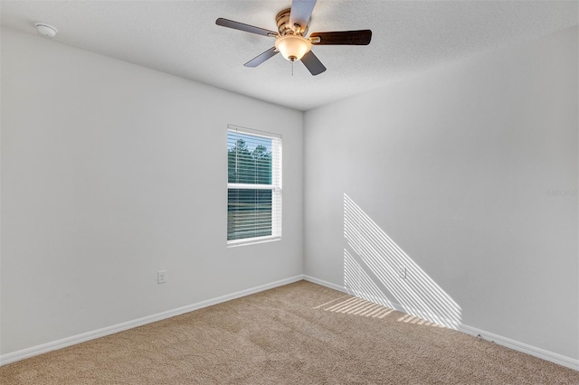 unfurnished room featuring ceiling fan, light colored carpet, and a textured ceiling