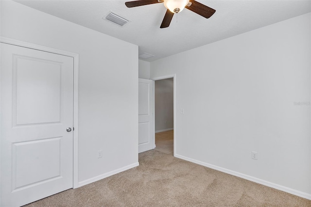 unfurnished bedroom featuring ceiling fan and light colored carpet