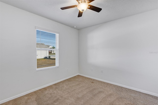 carpeted empty room featuring ceiling fan and a textured ceiling