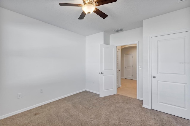 carpeted empty room with ceiling fan and a textured ceiling