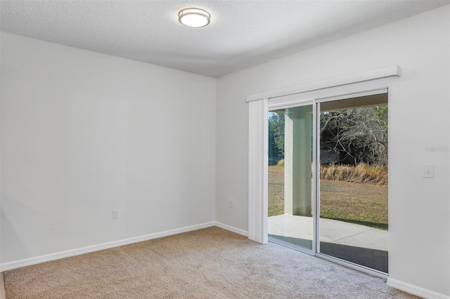 carpeted empty room featuring a textured ceiling