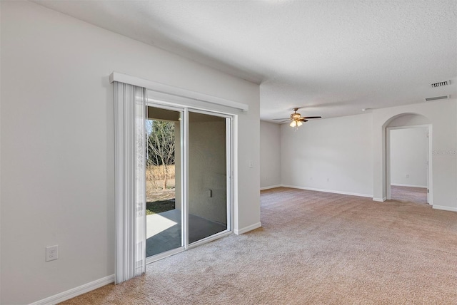 spare room with ceiling fan, light carpet, and a textured ceiling