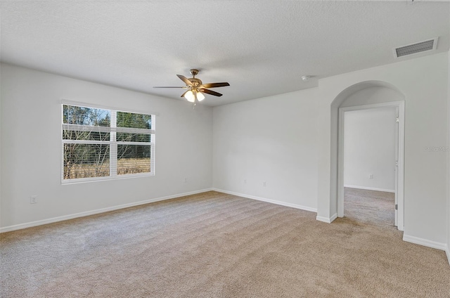 carpeted empty room featuring ceiling fan and a textured ceiling