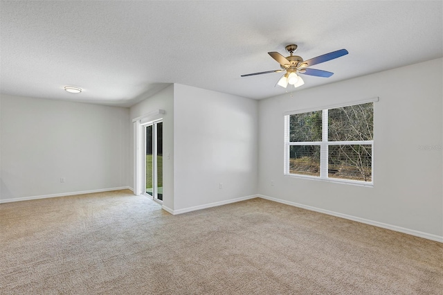 carpeted empty room with ceiling fan and a textured ceiling