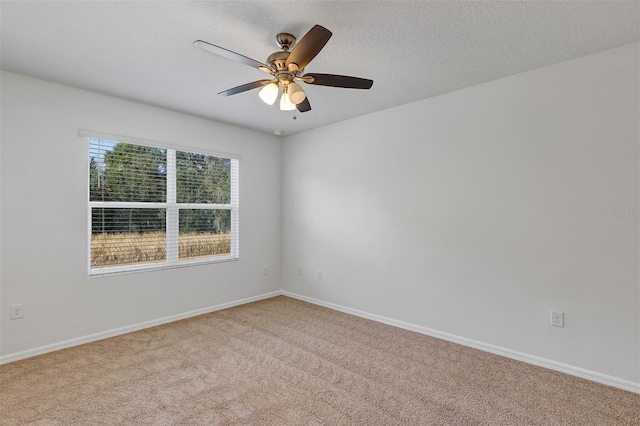 carpeted empty room featuring ceiling fan and a textured ceiling