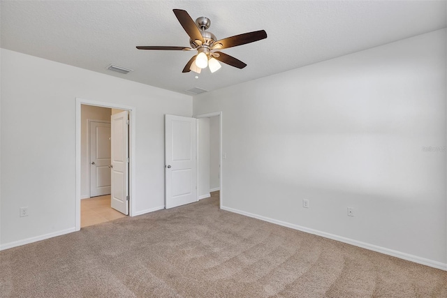 unfurnished bedroom featuring ceiling fan, light carpet, and a textured ceiling