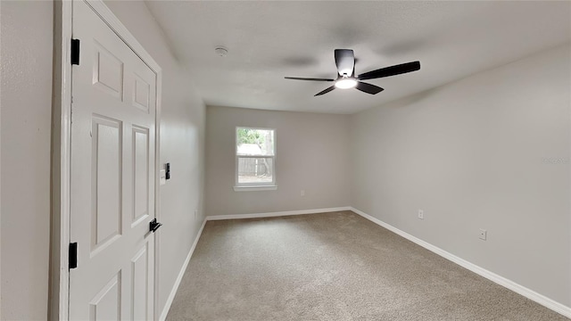 carpeted spare room with ceiling fan