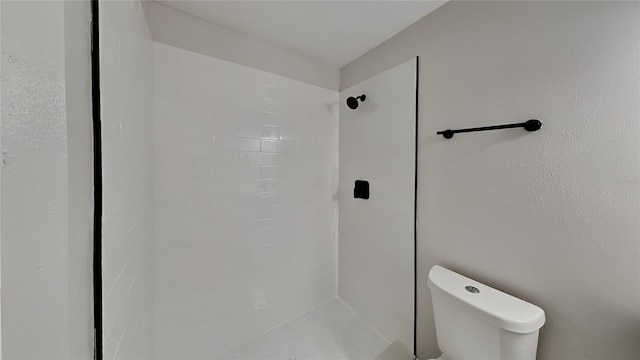 bathroom with toilet and tiled shower