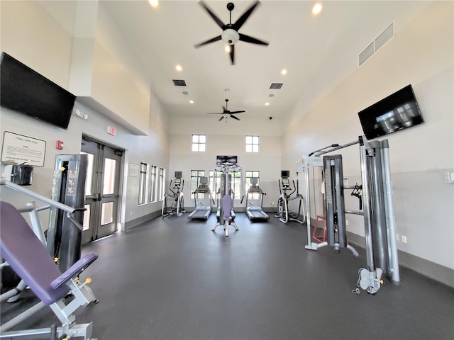 gym featuring a high ceiling, ceiling fan, and french doors