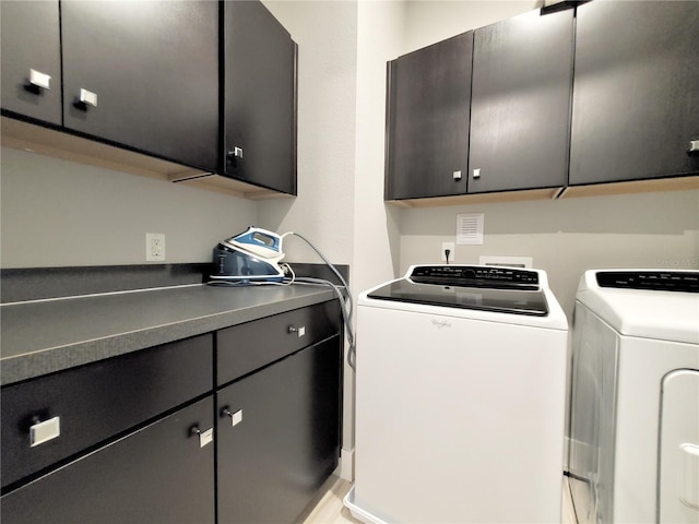 laundry area with washer and clothes dryer and cabinets