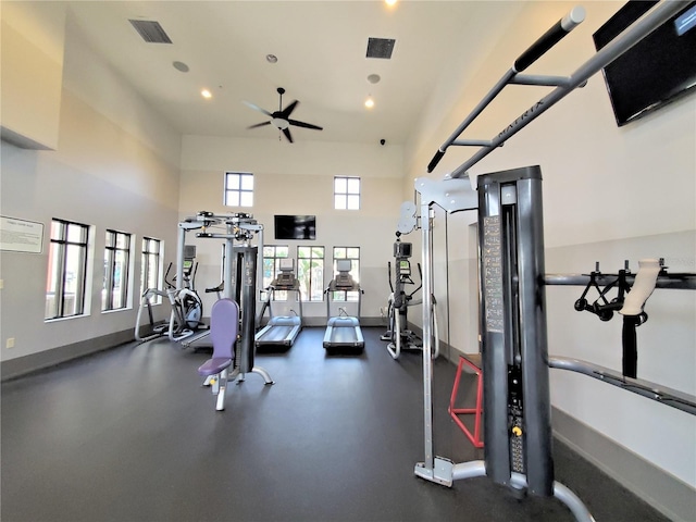 gym with ceiling fan and a high ceiling