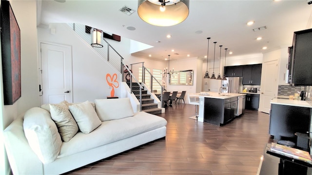 living room featuring sink, dark wood-type flooring, and crown molding