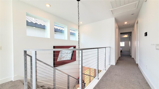 hallway featuring a healthy amount of sunlight and carpet flooring