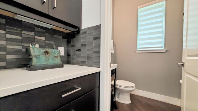 bathroom with toilet, vanity, and hardwood / wood-style floors