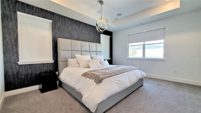 bedroom featuring a tray ceiling and light colored carpet