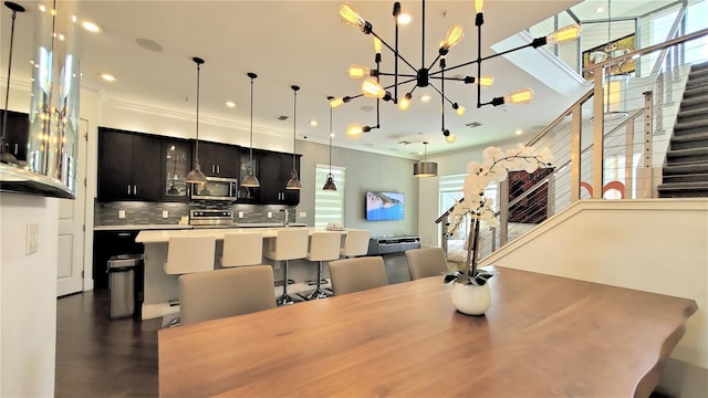 dining space with a notable chandelier, crown molding, and dark hardwood / wood-style floors