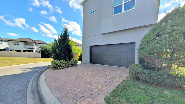 view of property exterior with a garage and a lawn