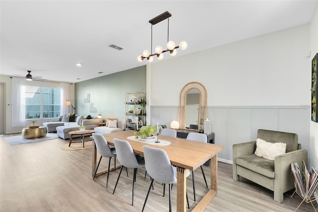 dining area with a notable chandelier and light hardwood / wood-style floors