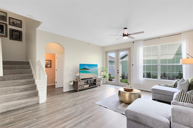 living room featuring french doors, ceiling fan, and light wood-type flooring