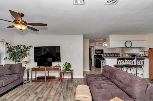 living room featuring hardwood / wood-style flooring and ceiling fan