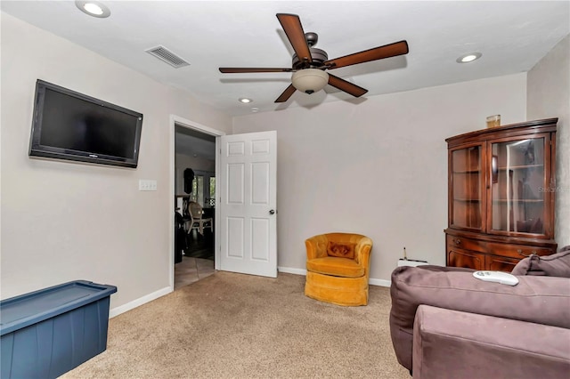 living area featuring light colored carpet and ceiling fan